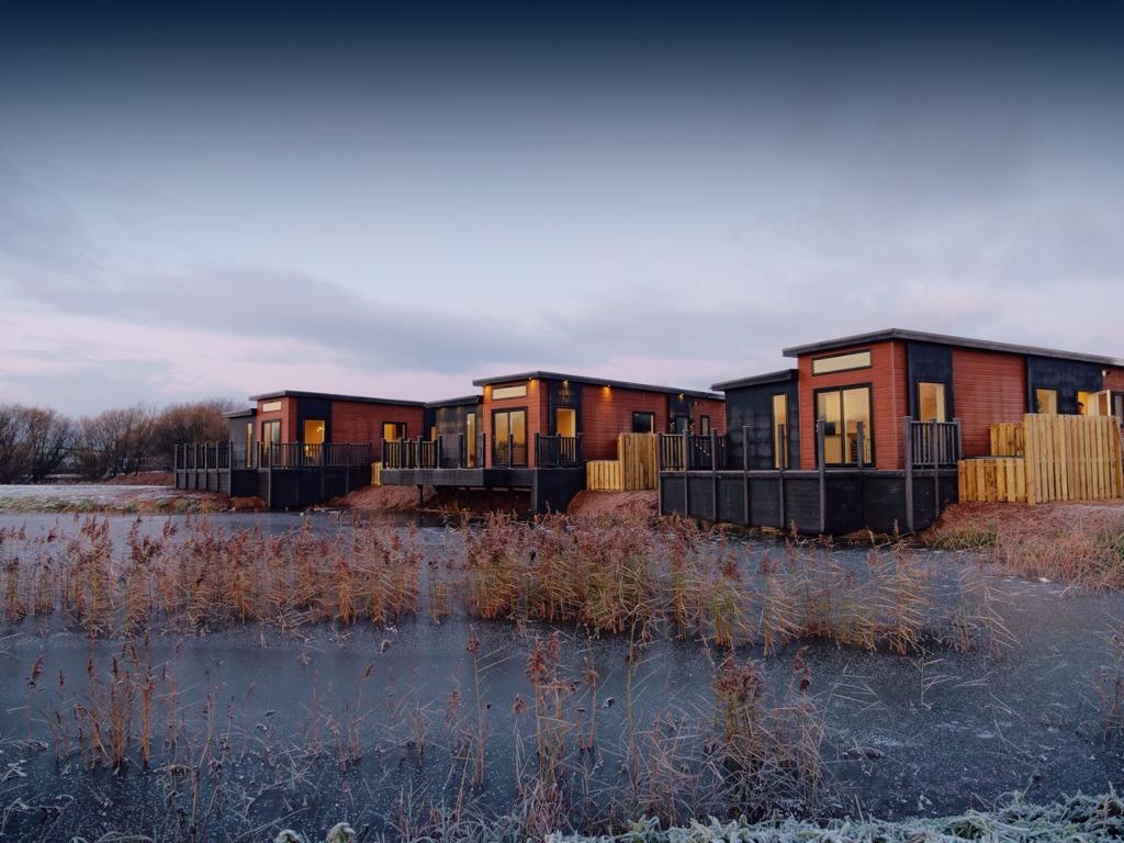 Lodges lit at dusk in winter frost